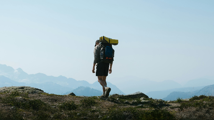 a man with a backpack walking up a hill